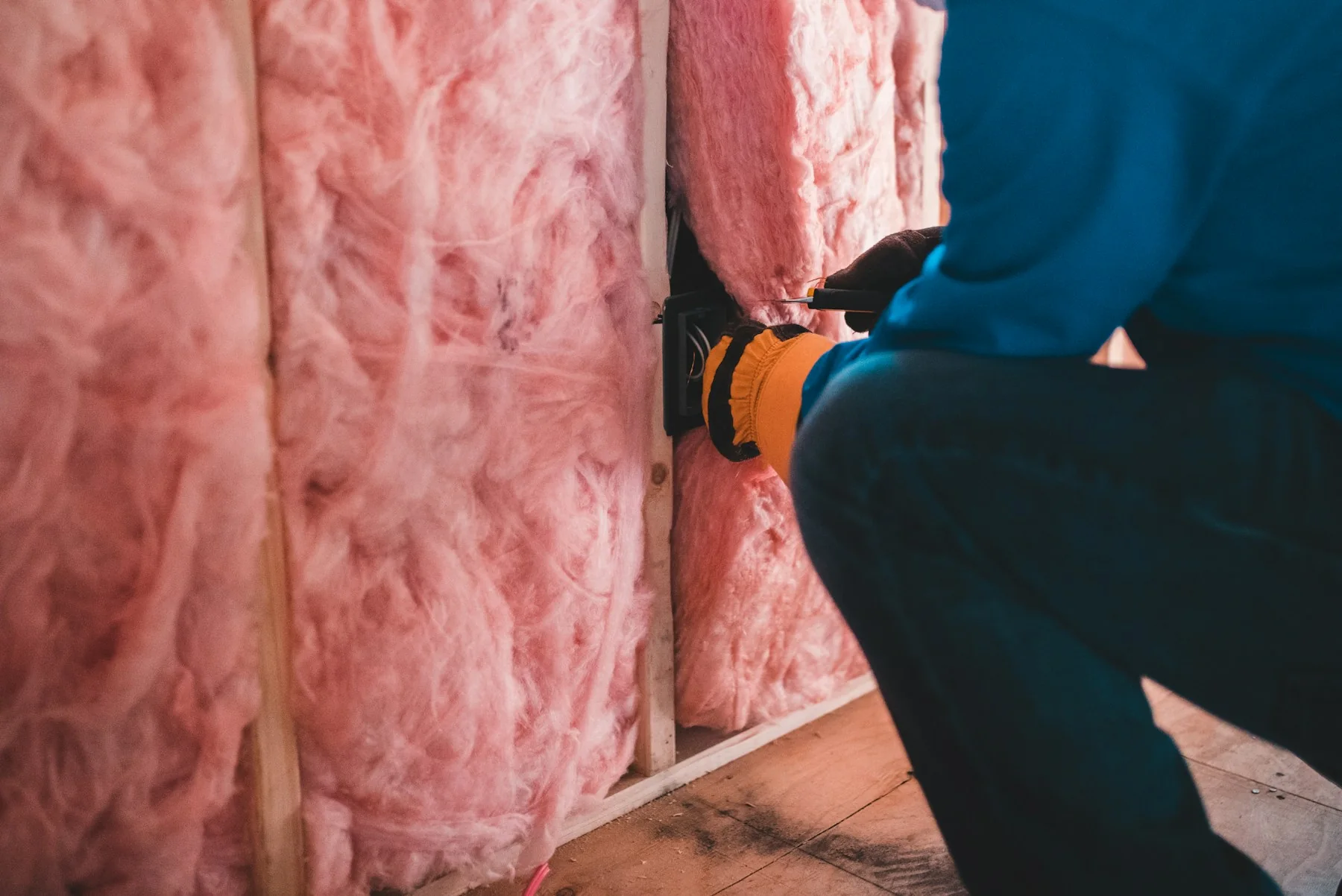 Travaux dans un mur ouvert avec laine isolante visible