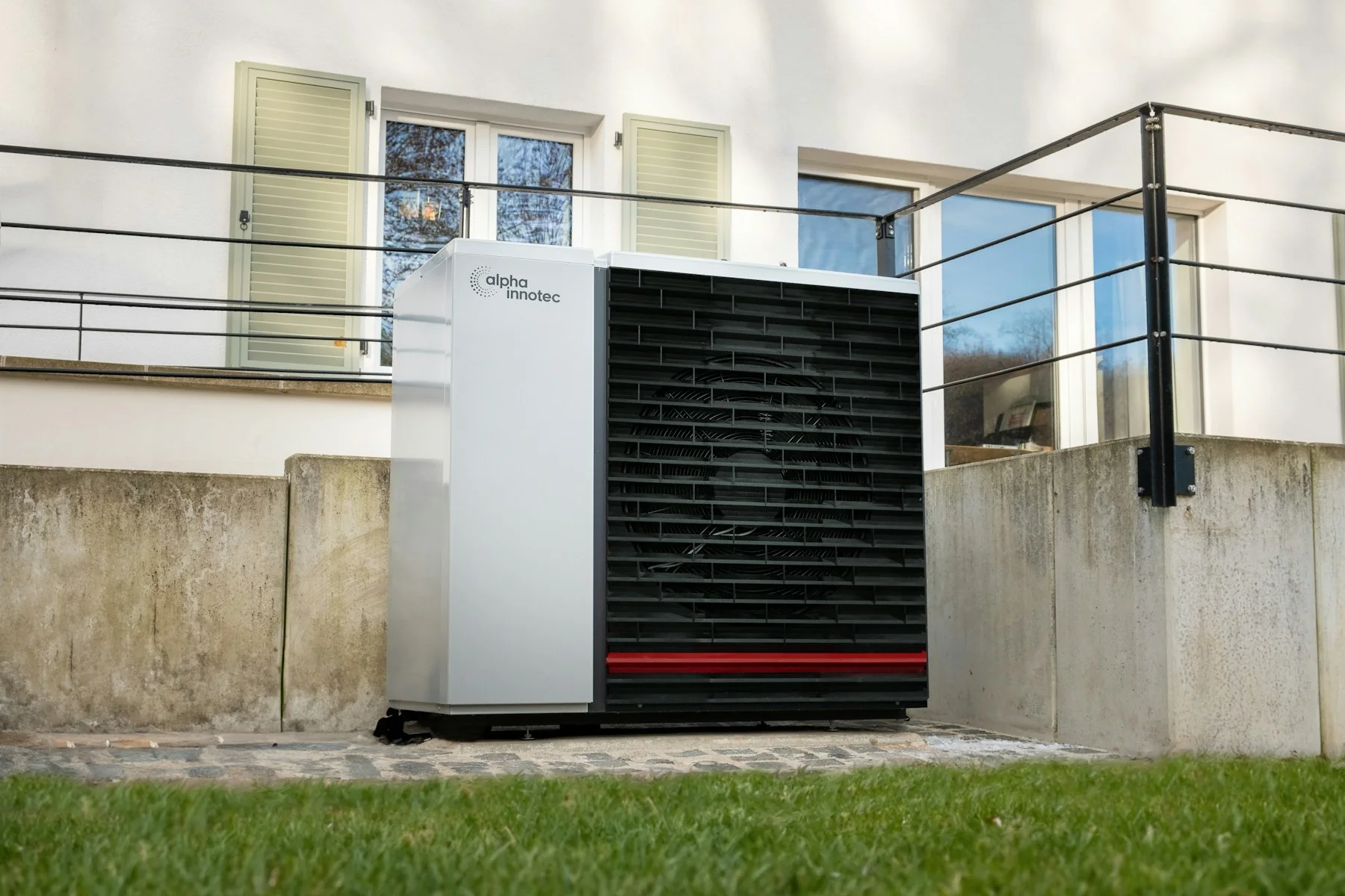 Unité extérieure d'une pompe à chaleur air-eau devant une maison
