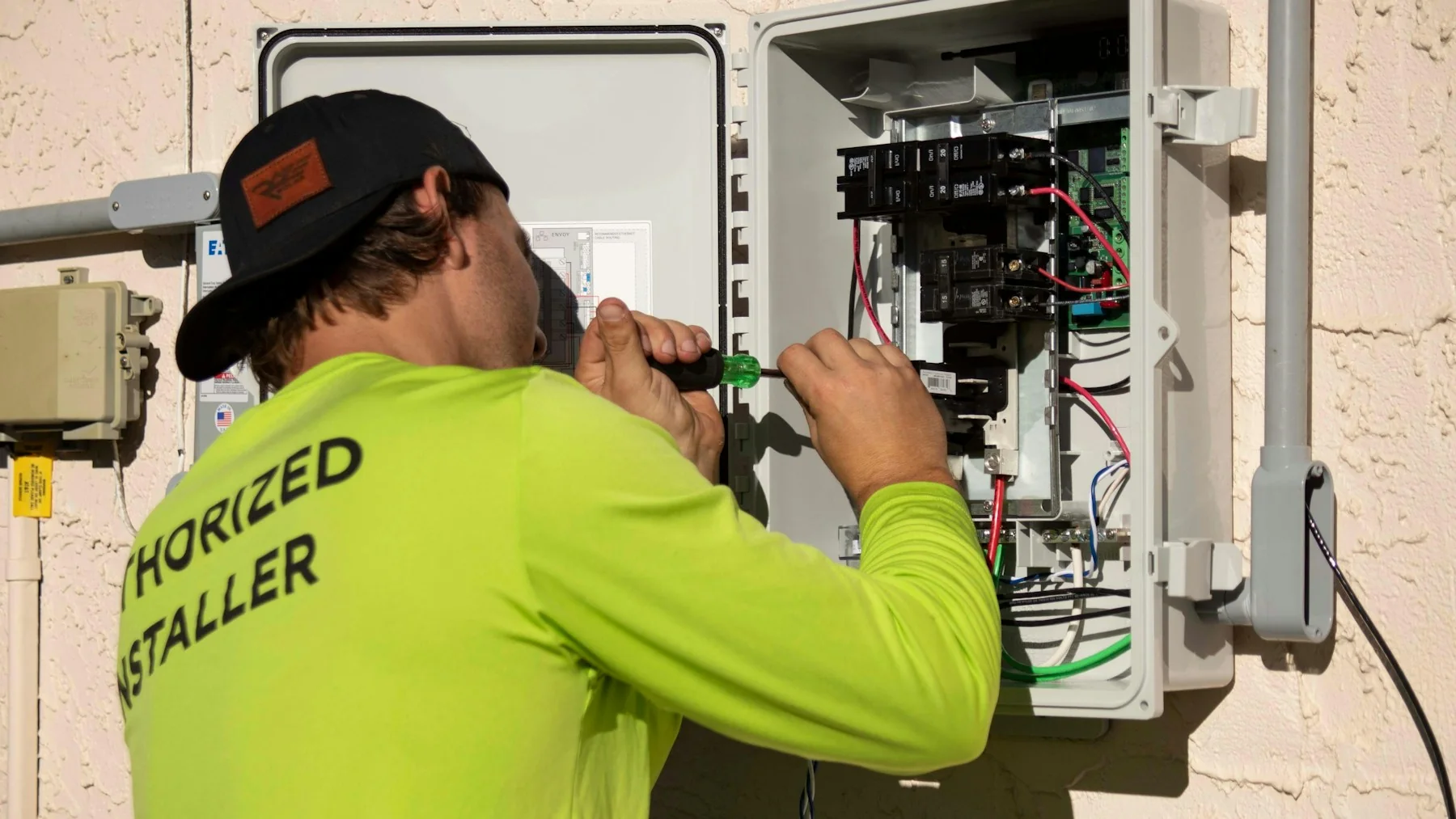 Technicien intervenant sur un tableau de contrôle électrique
